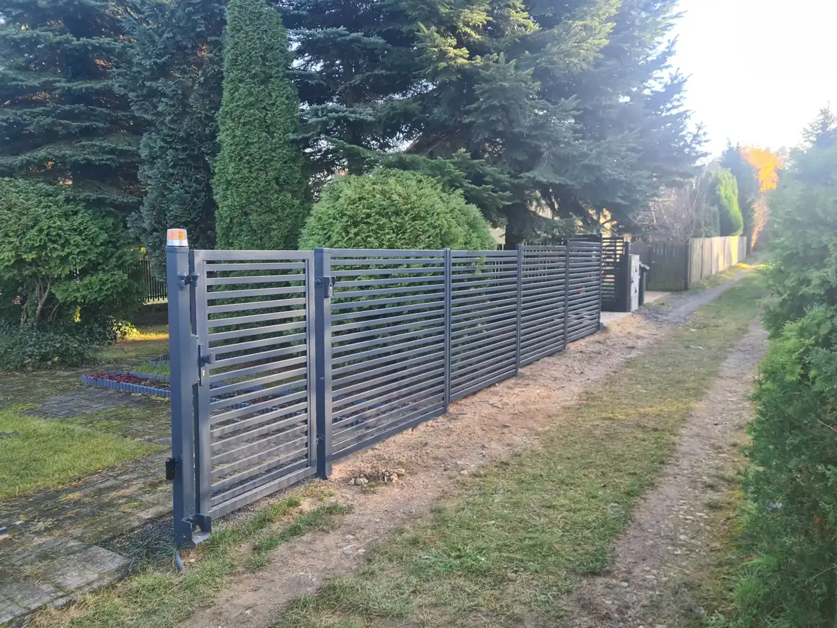Furtka i ogrodzenie z poziomych profili wzdłuż posesji
